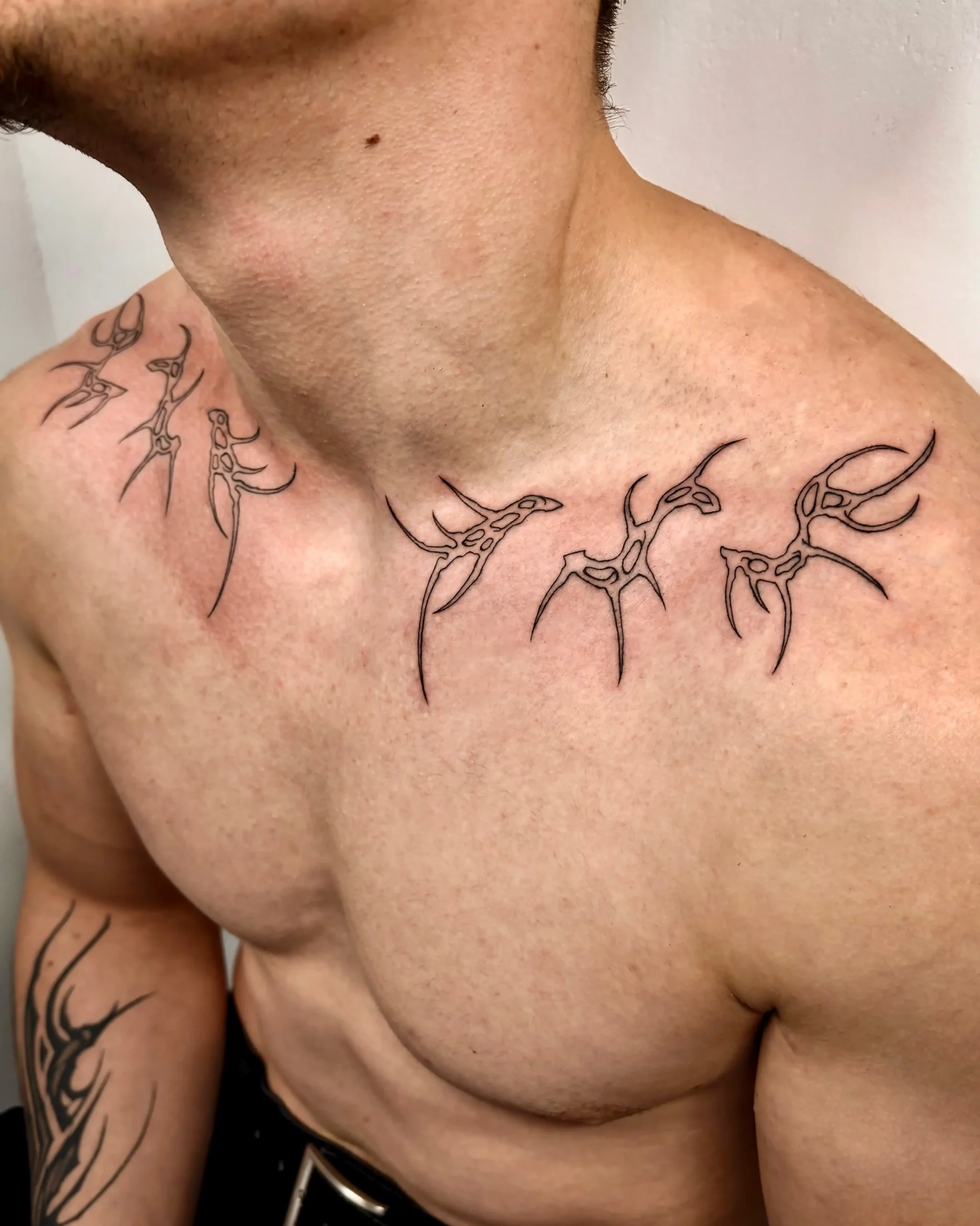 Modern cyber-sigilism neck and collarbone tattoo with sharp black linework - Walk In Tattoo Budapest