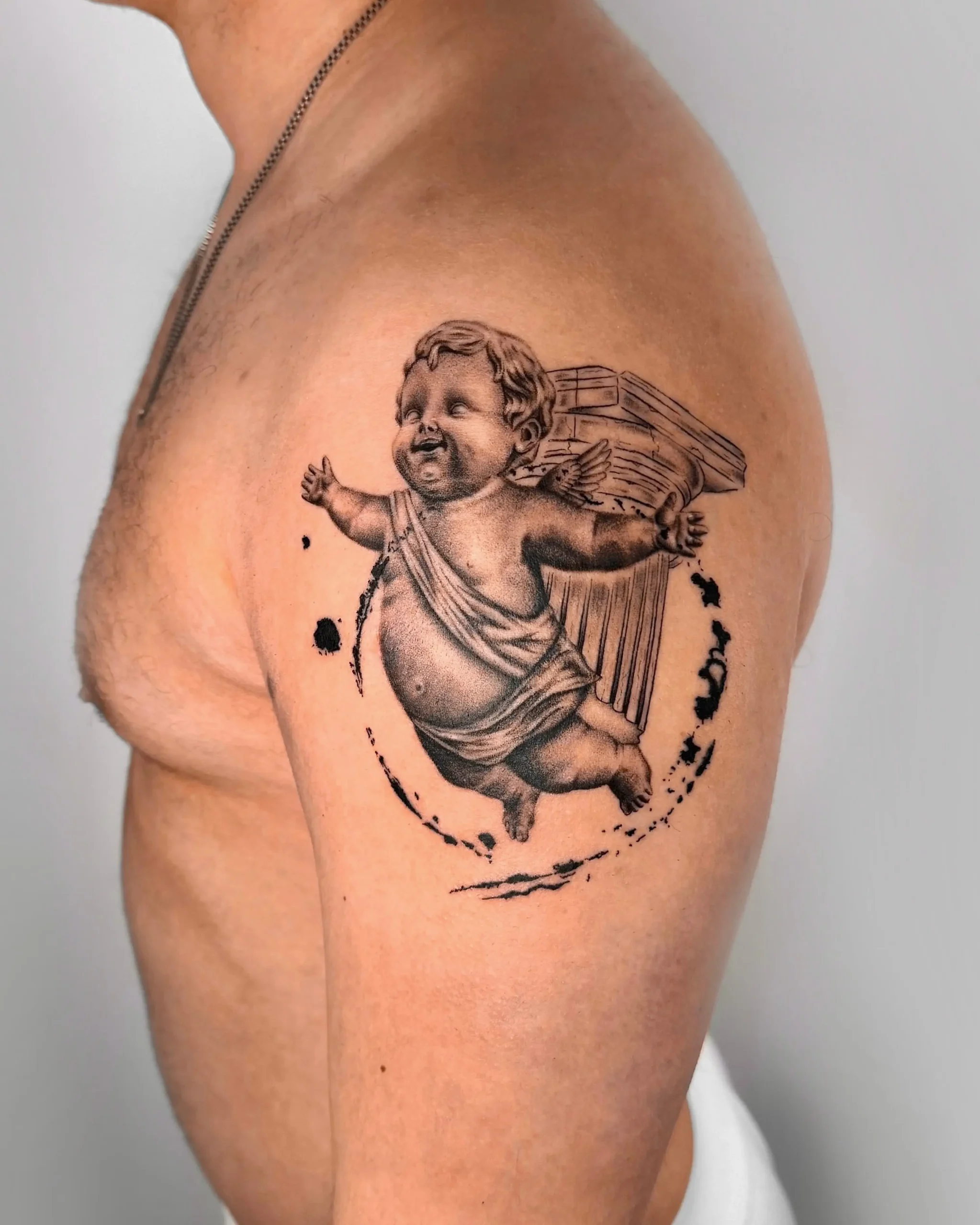 Renaissance style cherub angel tattoo with Corinthian column on shoulder - Walk In Tattoo Budapest